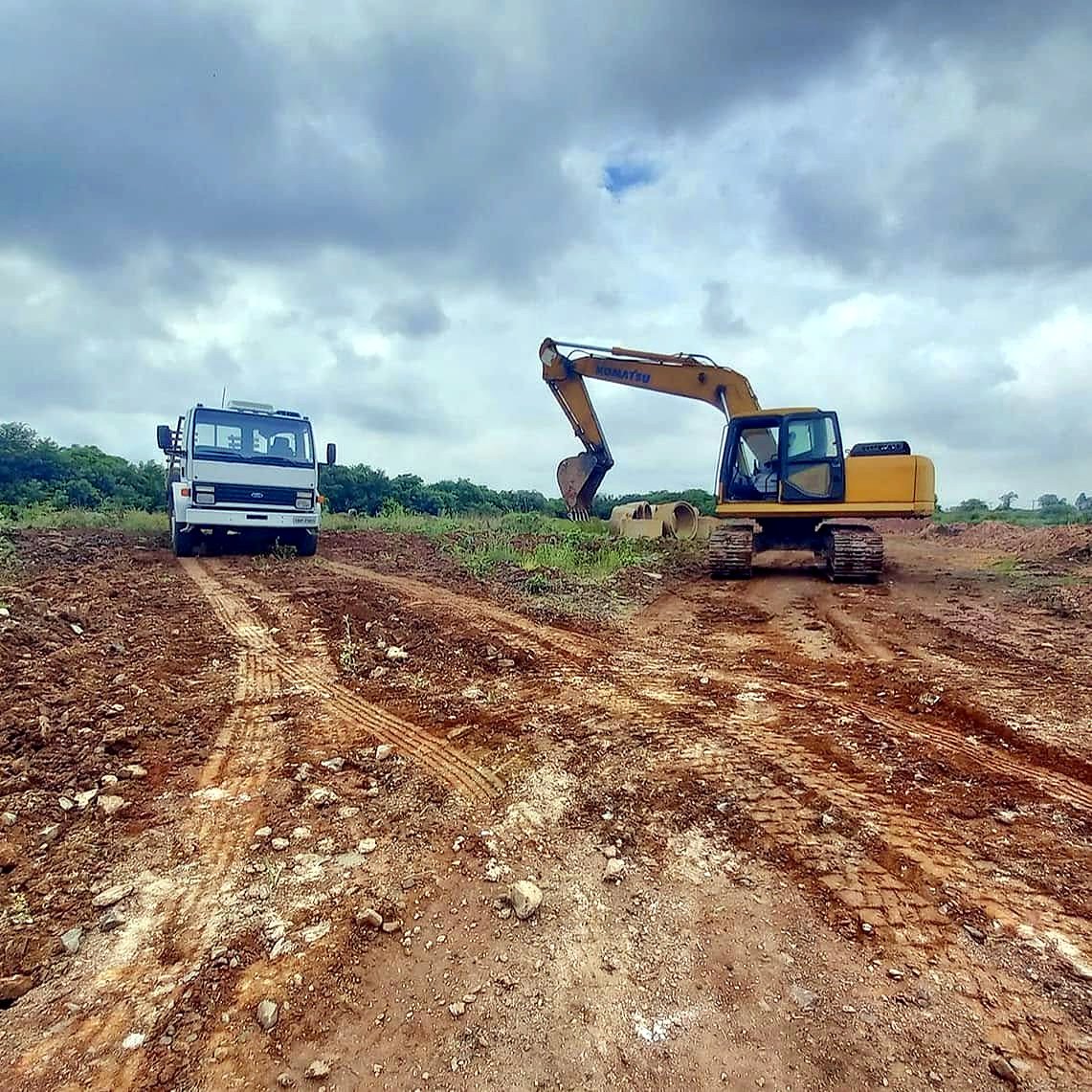 Escavadeira hidráulica Komatsu e caminhão caçamba da JC Terraplenagem em terreno em Canoas
