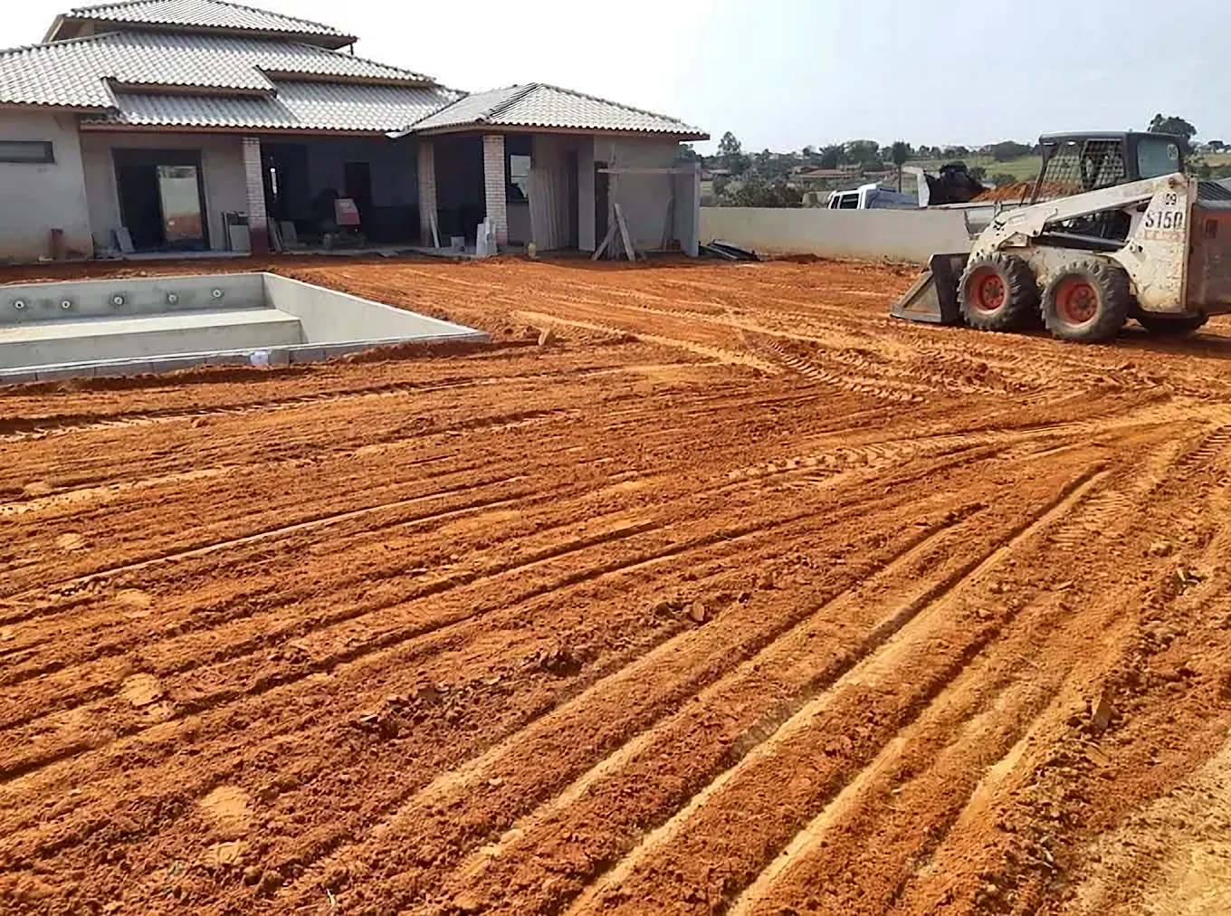 Terreno acertado em volta de casa nova com piscina em Boituva, com a minicarregadeira ao fundo
