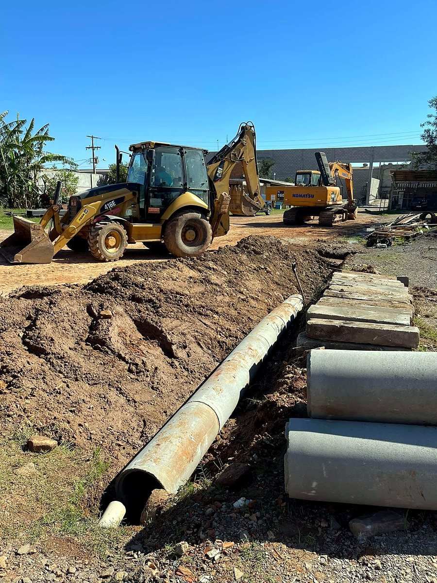 Retroescavadeira CAT 416E na abertura de vala para tubos de drenagem em Canoas